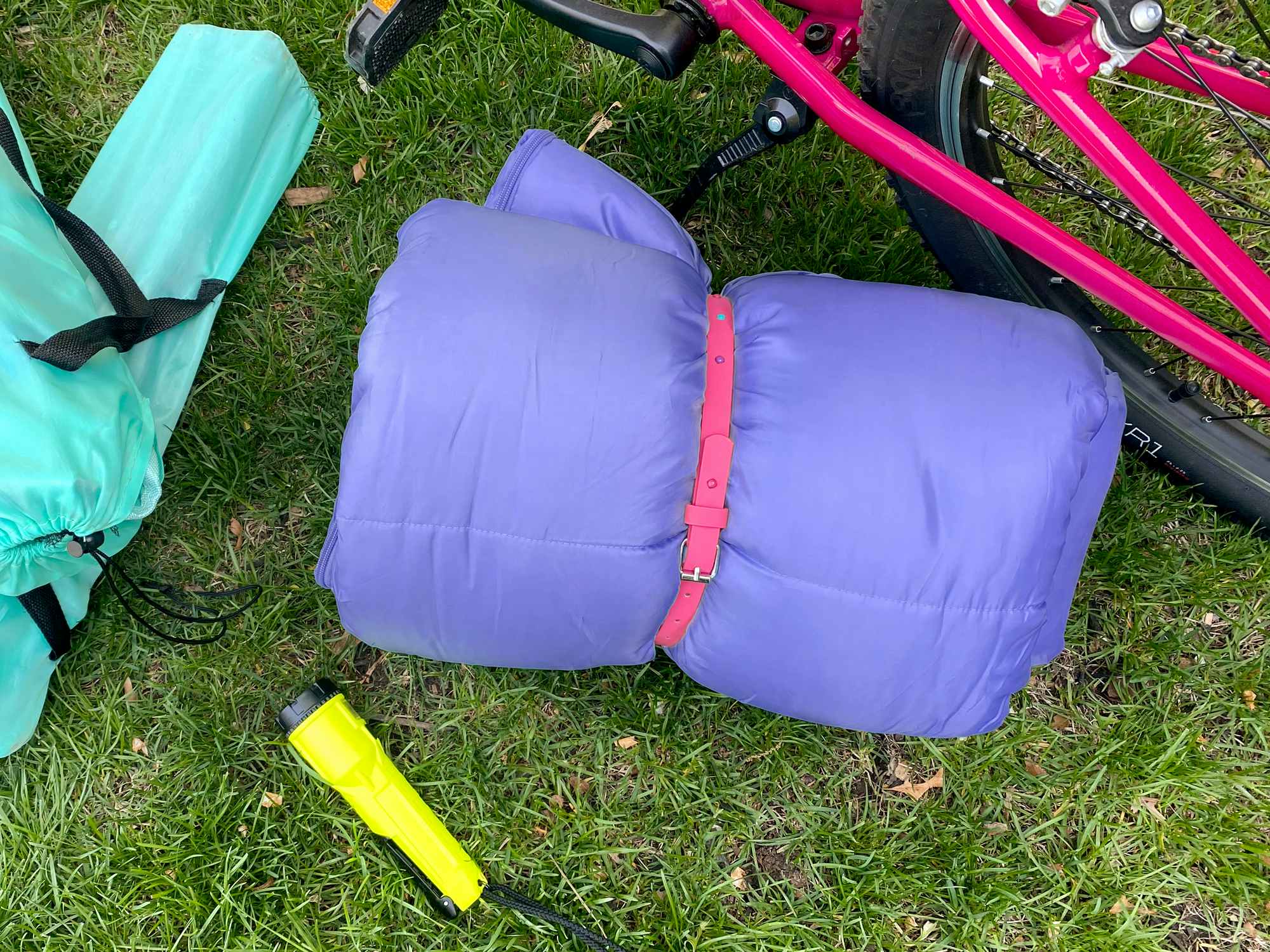 a sleeping bag tied with a kids belt for camping