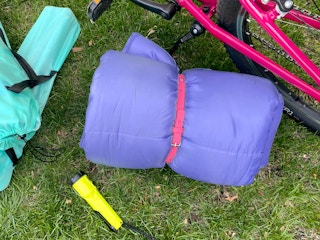a sleeping bag tied with a kids belt for camping