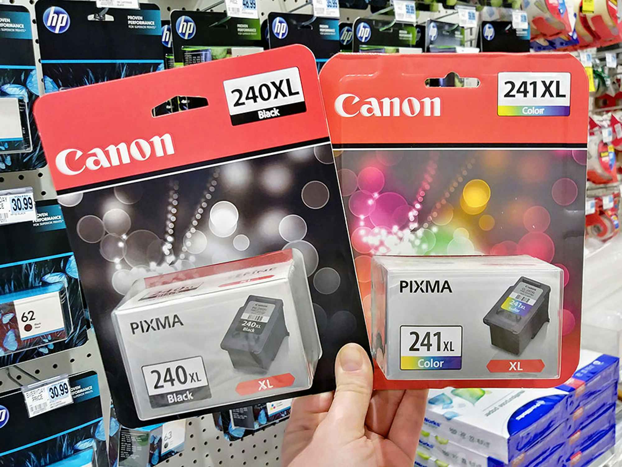a person holding canon printer ink in a store