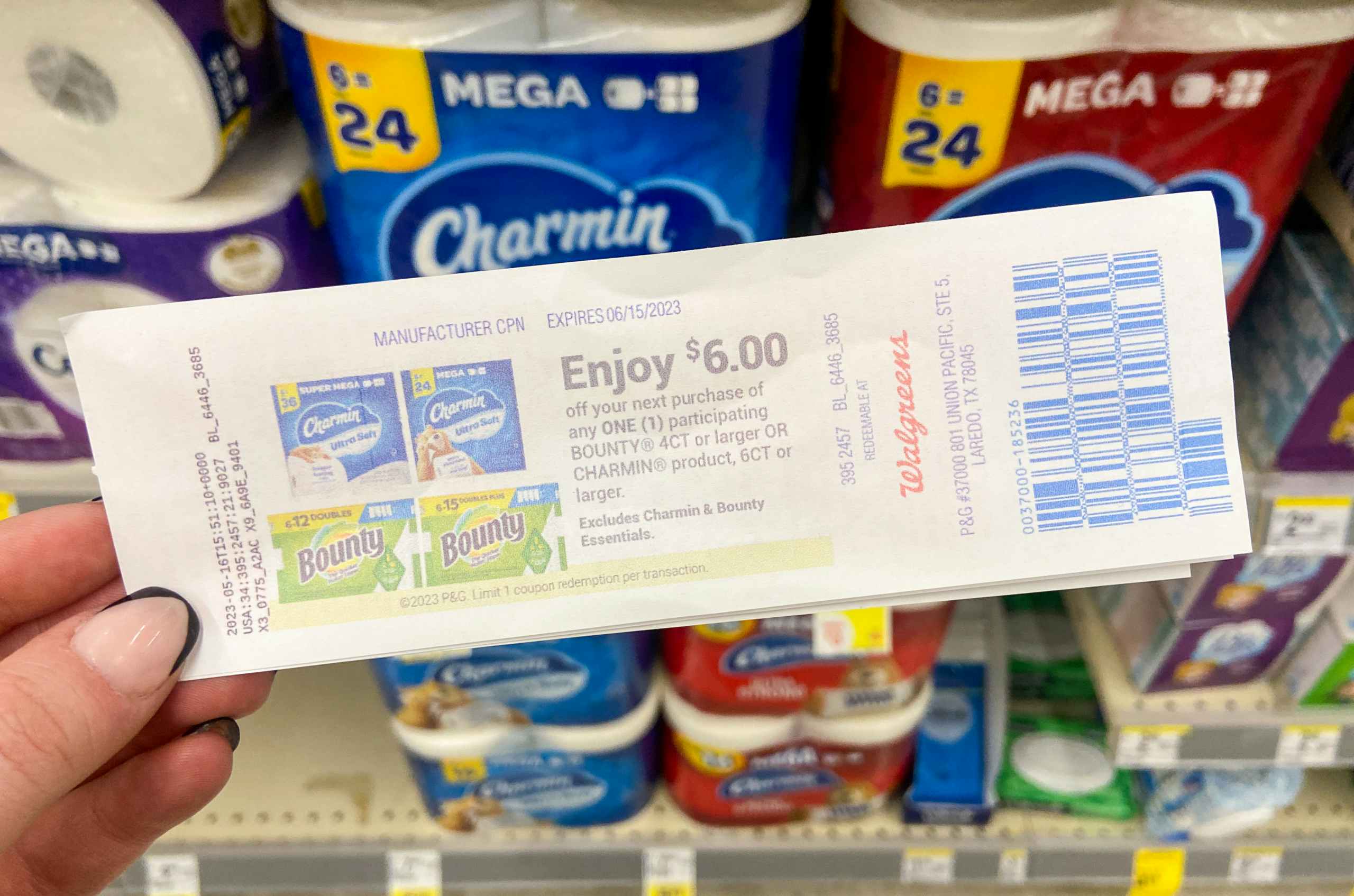 hand holding a charmin and bounty walgreens catalina coupon in a store aisle