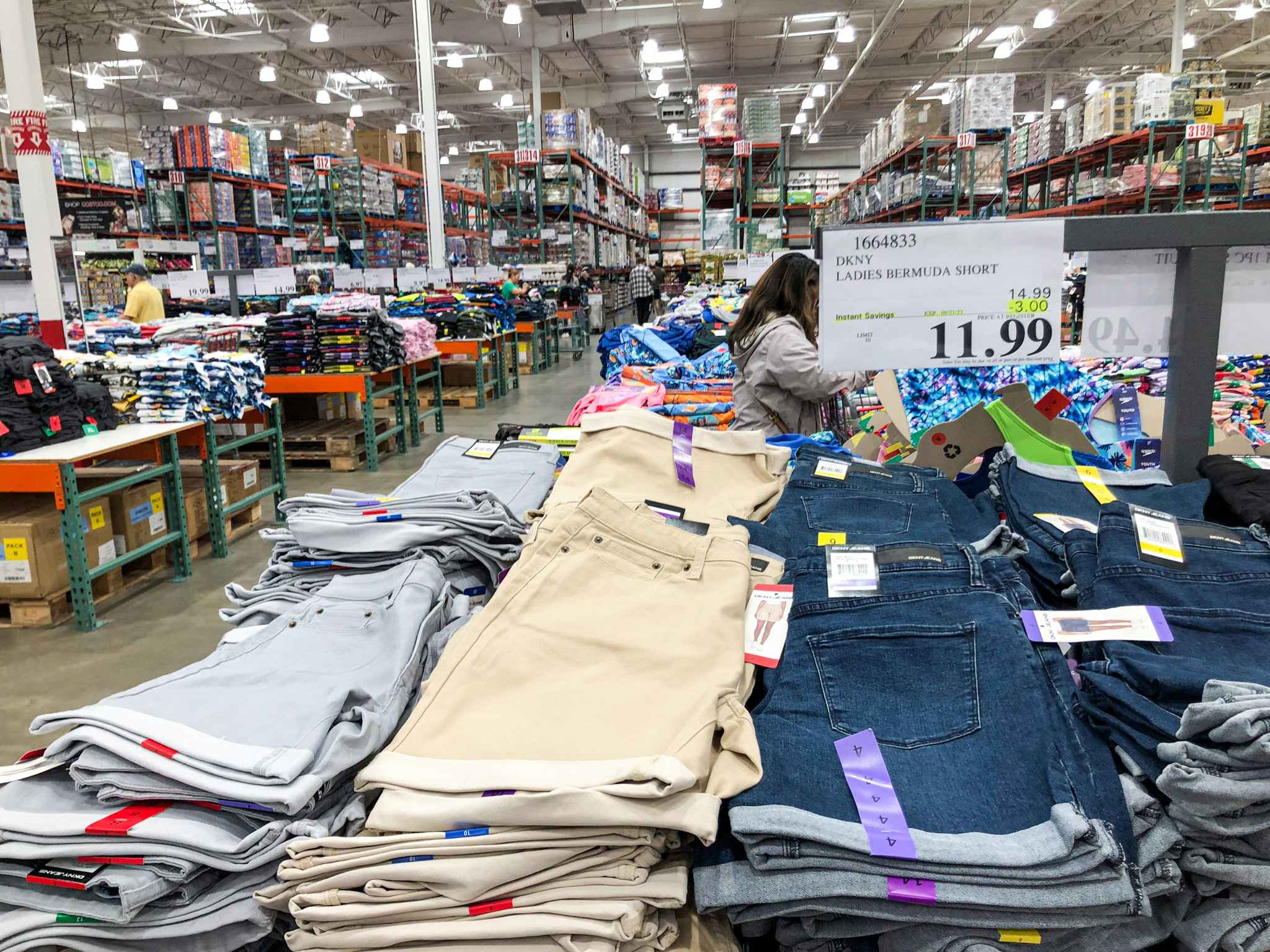 piles of bermuda shorts with a sign for 11.99