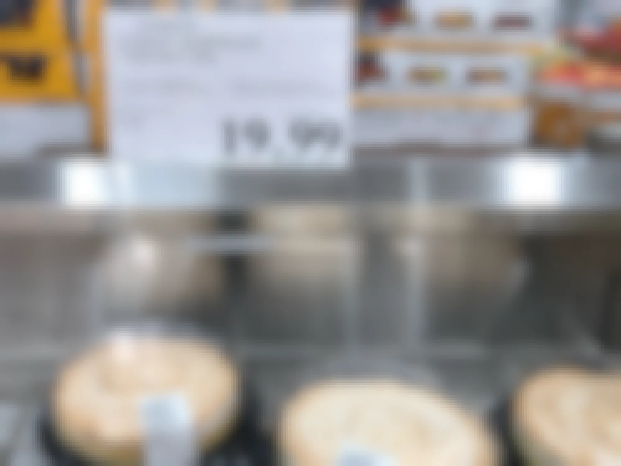 costco lemon meringue cheesecakes in cooler with $19.99 price tag