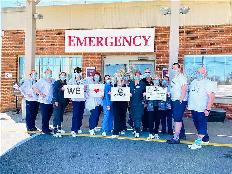 healthcare staff wearing crocs and holding signs