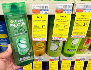 hand holding one bottle of Garnier Fructis shampoo next to sales tag