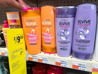 hand grabbing bottle of L'Oreal Elvive shampoo next to sales tag