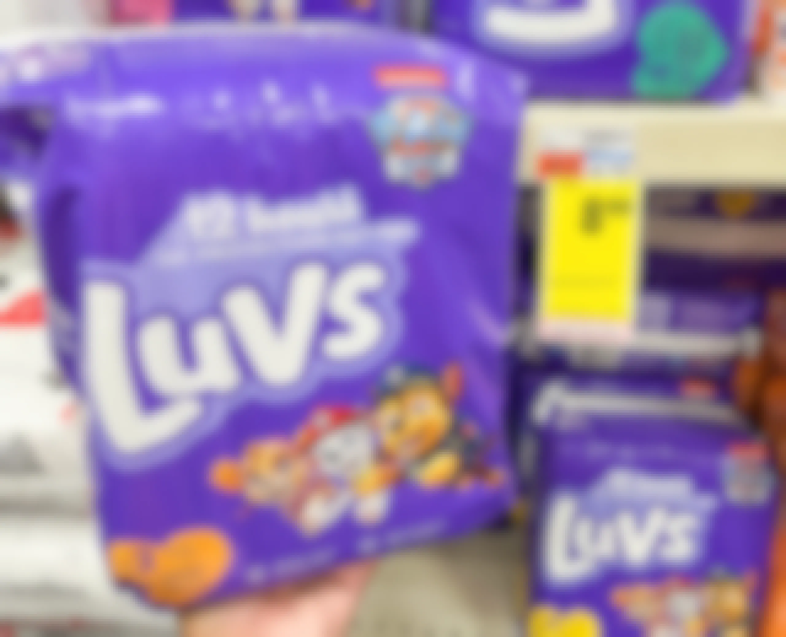 hand holding one pack of Luvs diapers next to sales tag