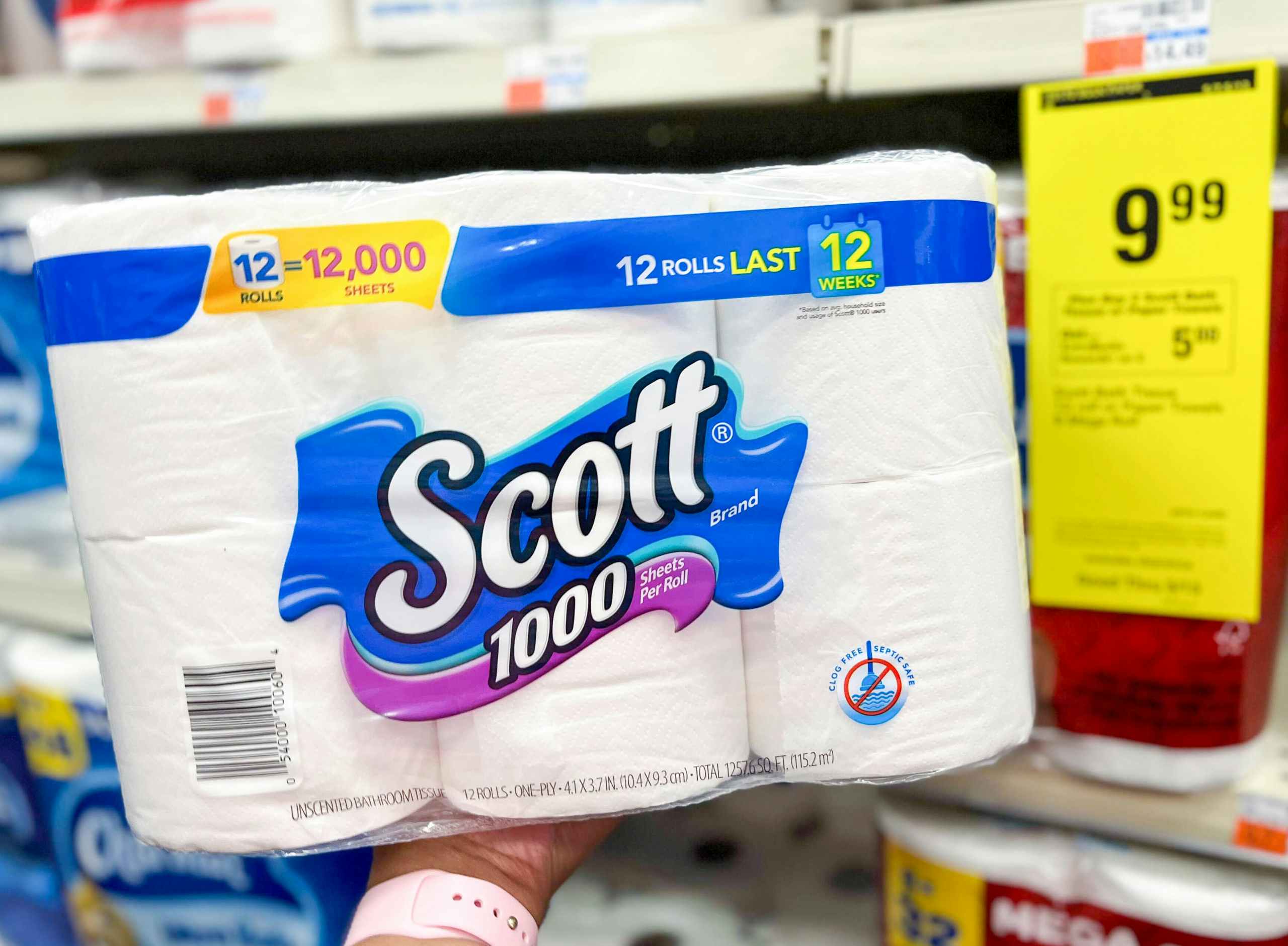 hand holding pack of Scott 1000 toilet paper next to sales tag