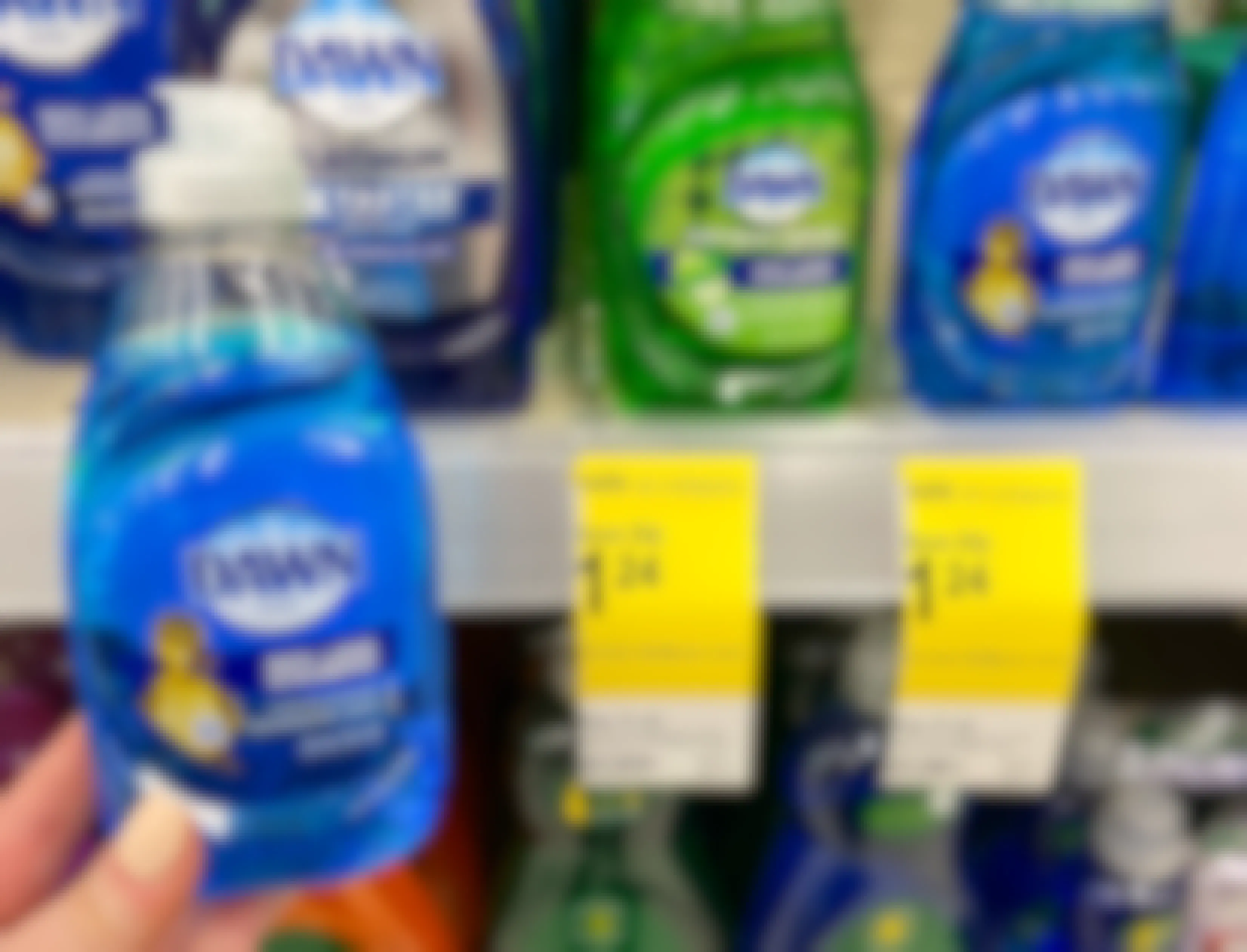 hand holding bottle of Dawn liquid dish soap next to walgreens sale tags