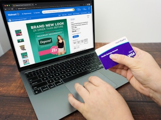 Someone looking at Depends on the Walmart website and holding their HSA debit card
