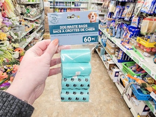 hand holding a pack of dog waste bags