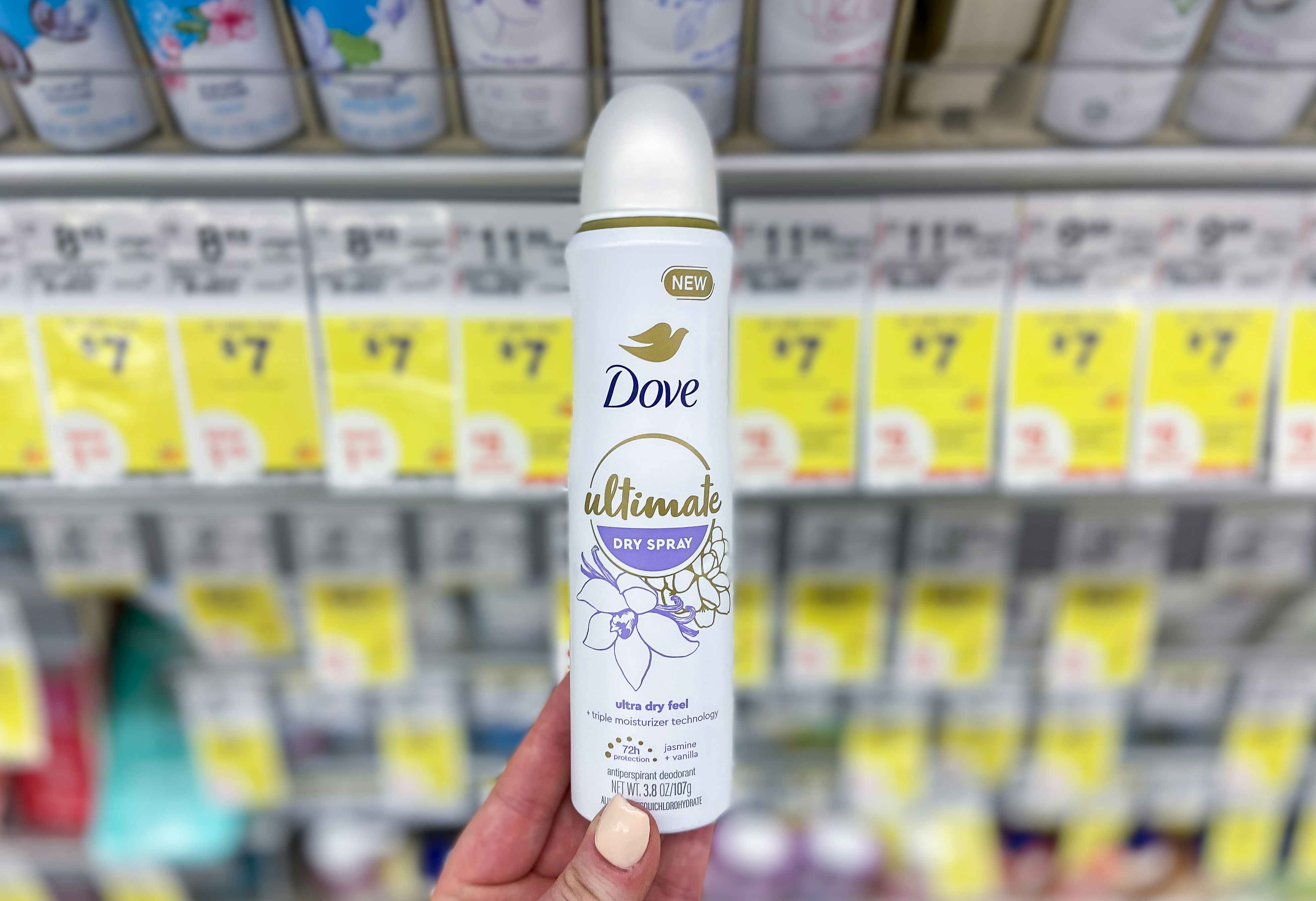 hand holding dove dry spray deodorant by walgreens sale tags