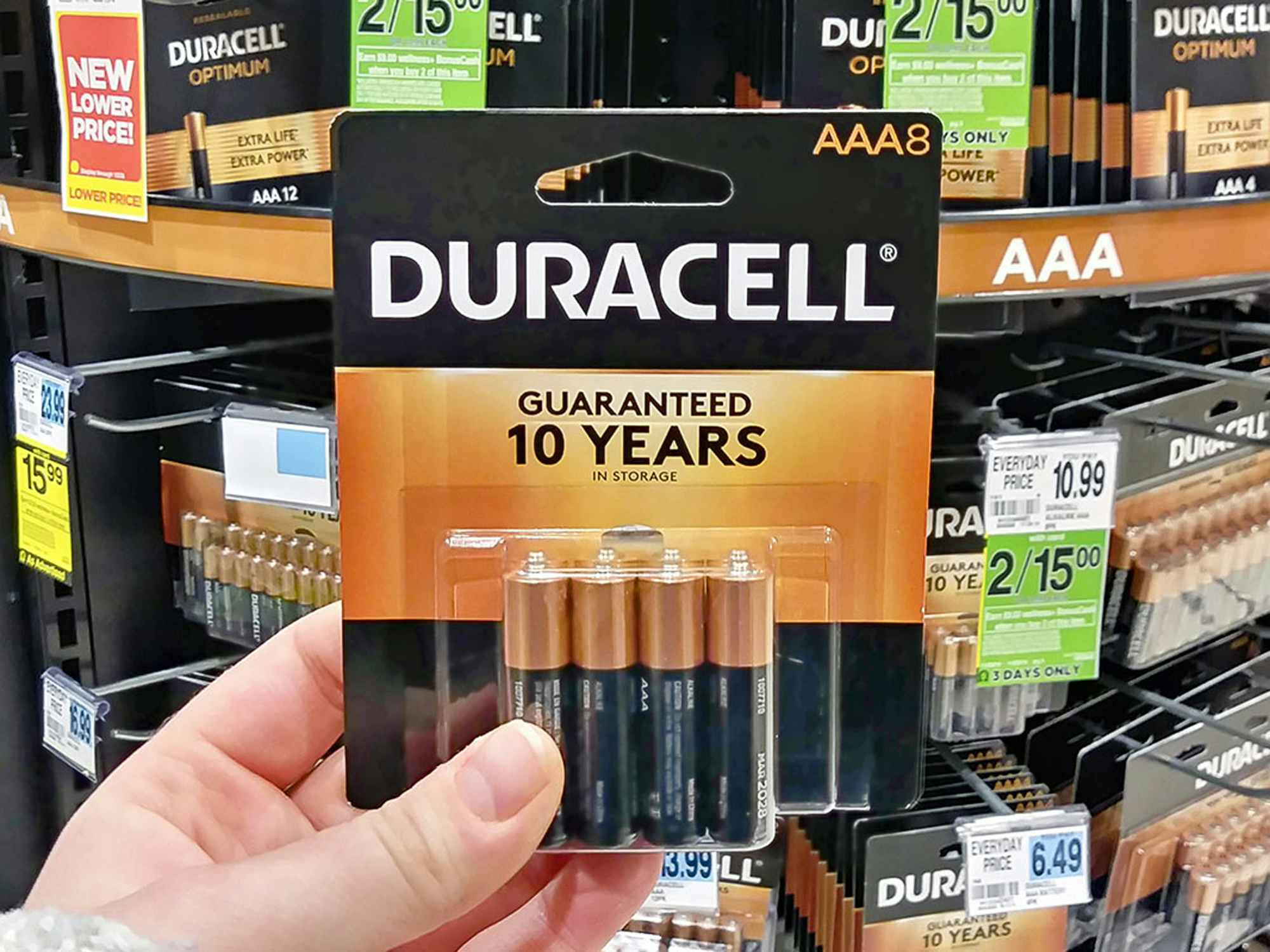 a person holding duracell batteries in a rite aid