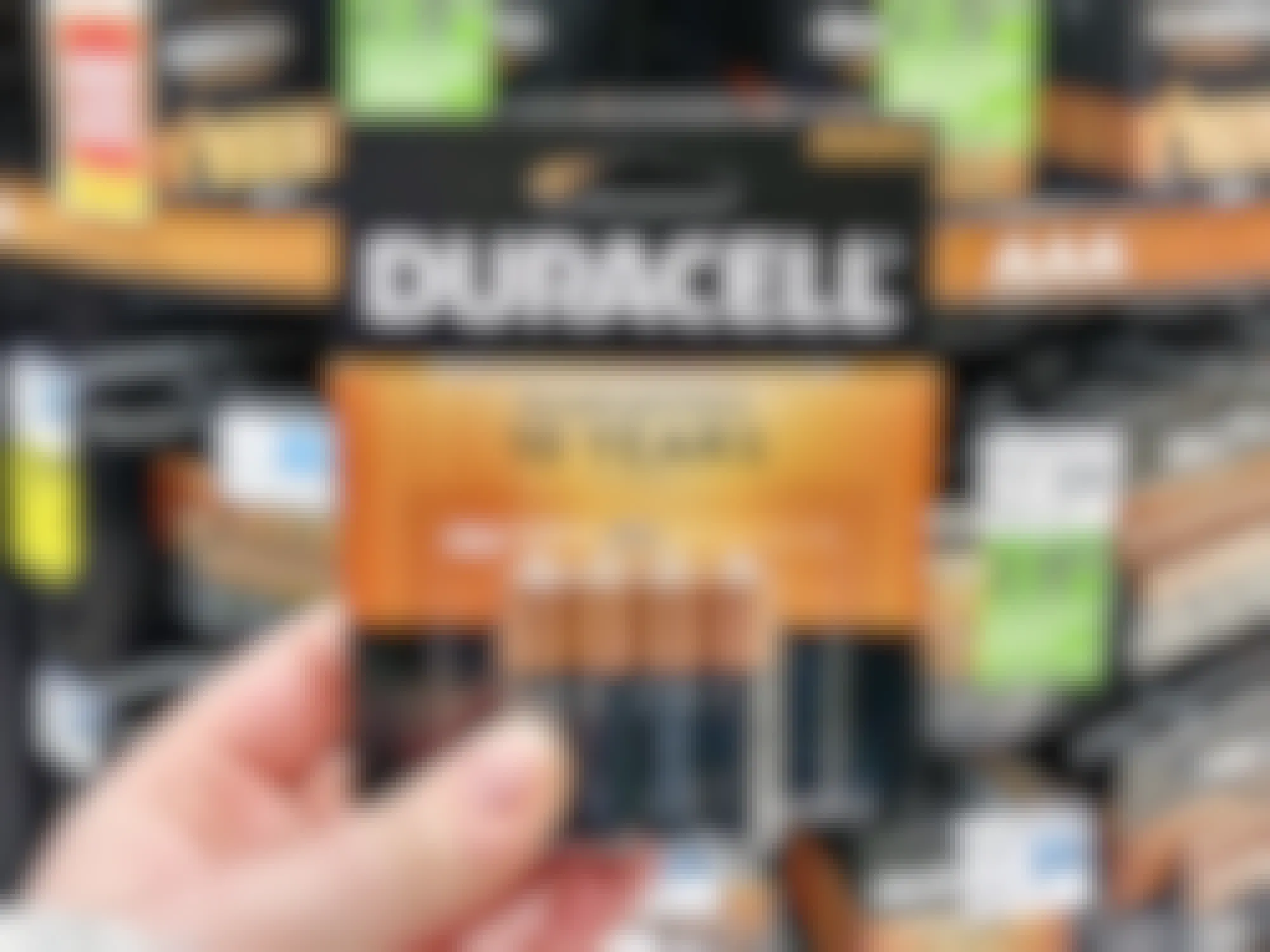 a person holding duracell batteries in a rite aid