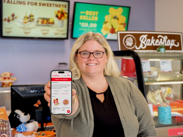 a person holding up a phone in edible arrangements 
