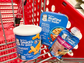 A variety of Gerber baby food sitting in a store cart.