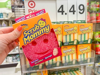 a hand holding a scrub mommy at target