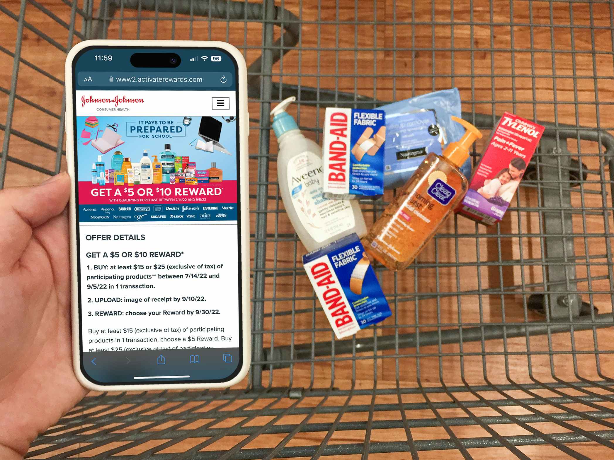 Someone holding a phone displaying the Offer Details for the Johnson & Johnson back to school rebate with a cart of eligible products in the background