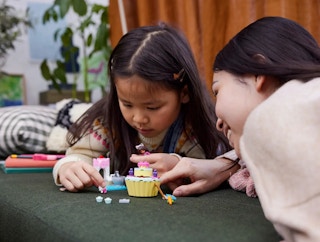 A mom and child playing with the Lego Gabby's Dollhouse set