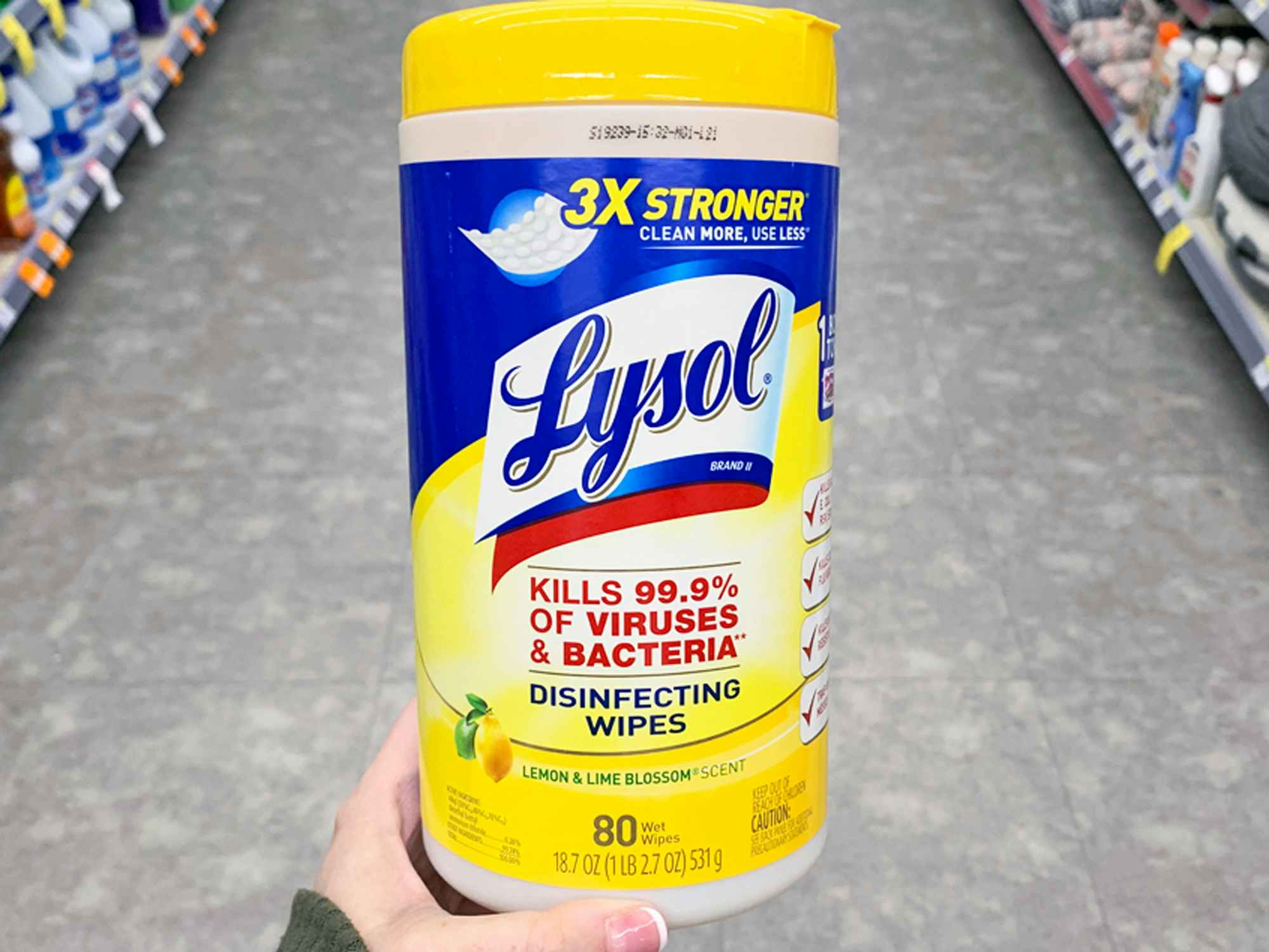 a person holding up lysol wipes in a store