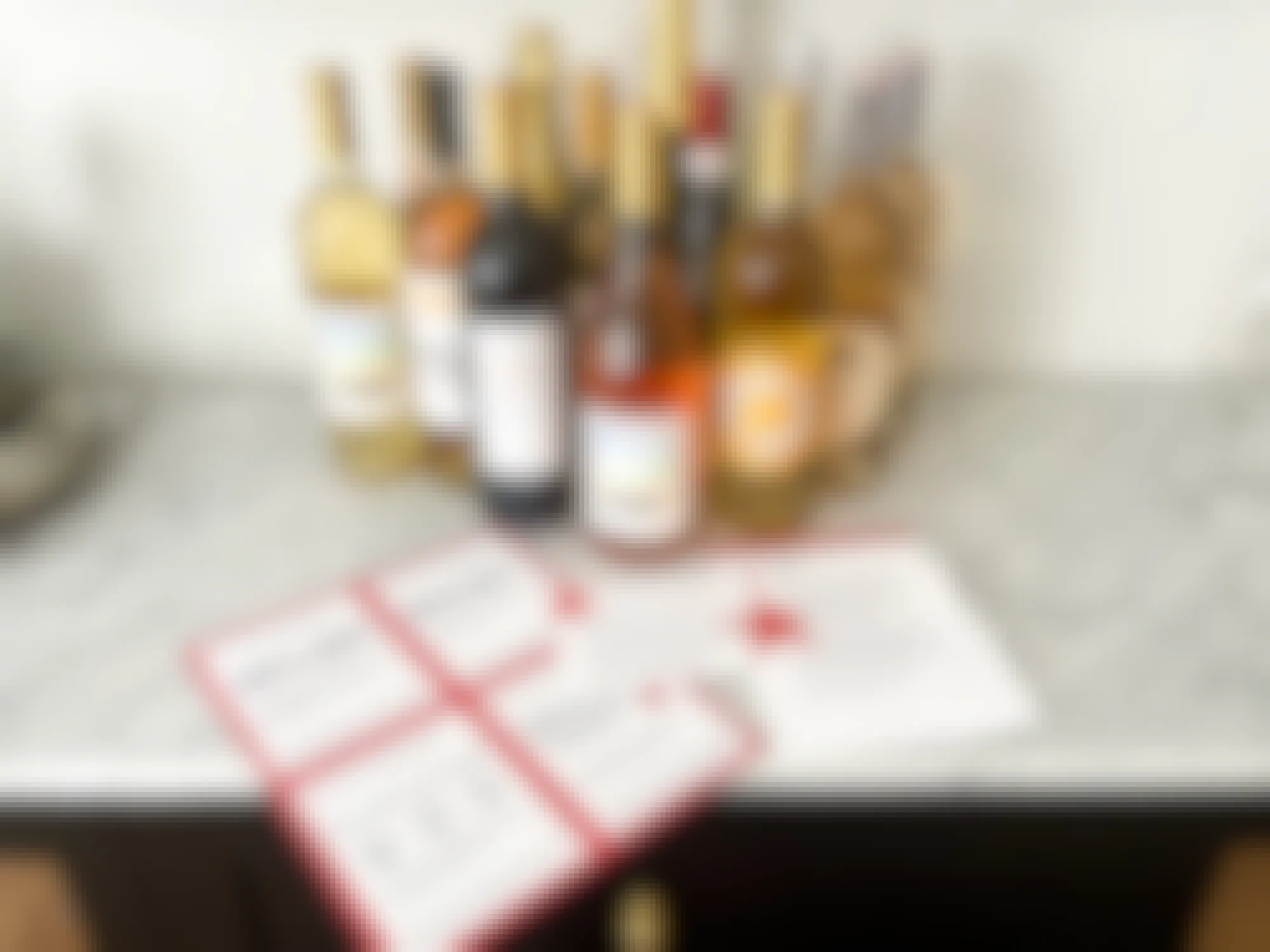 A group of bottles of wine on a counter with some Macy's Wine Shop coupons and information cards