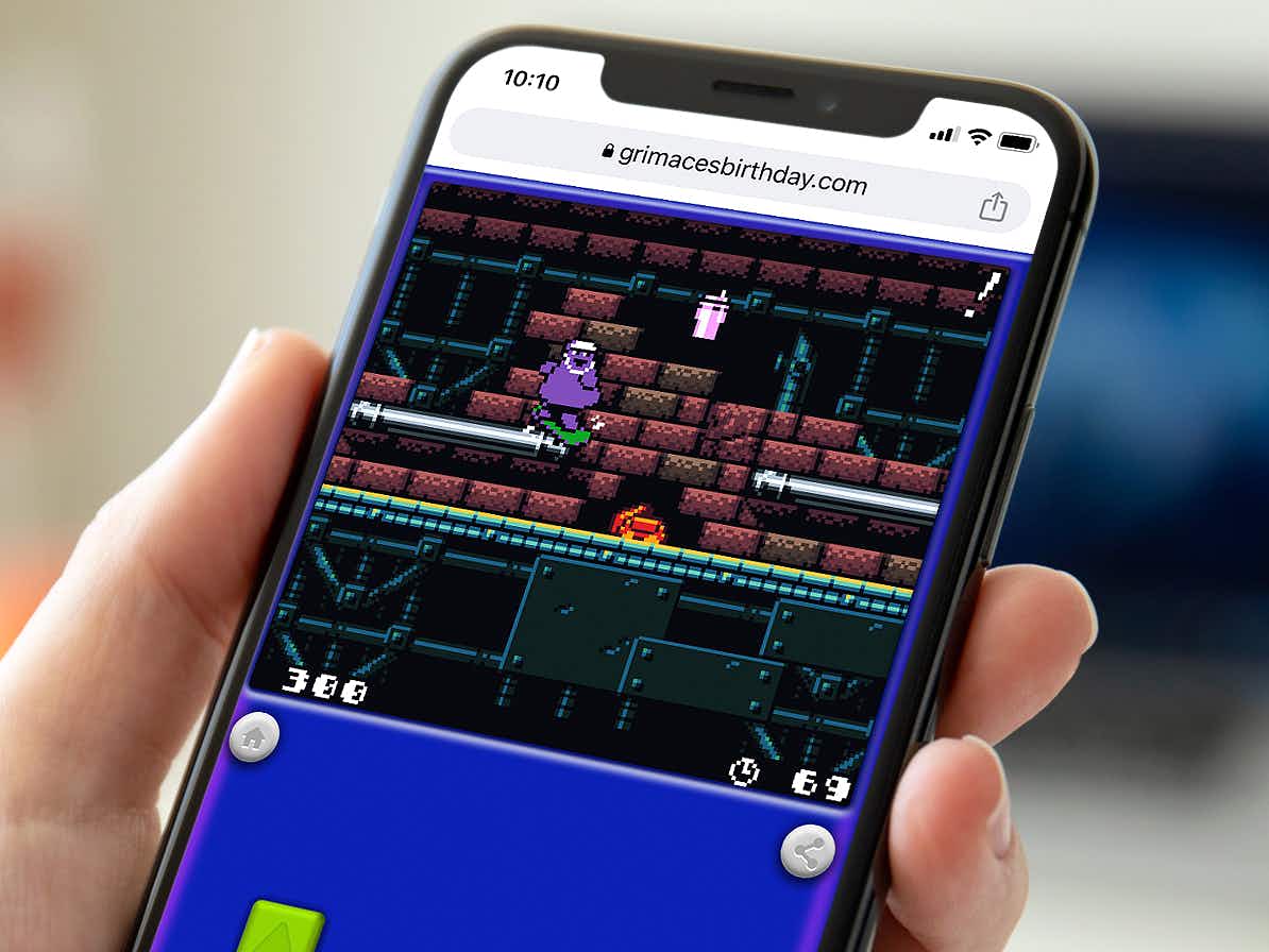 person on phone playing the new mcdonalds grimace 8-bit game online