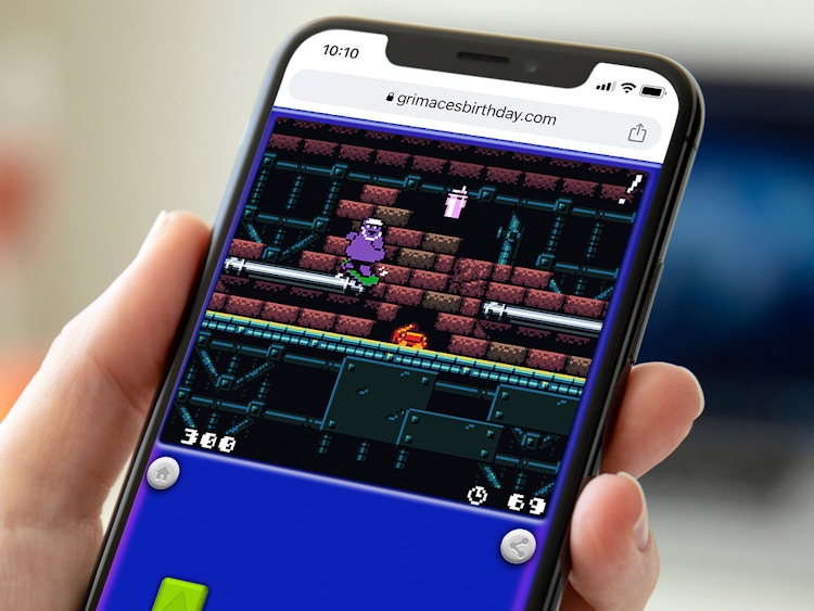 person on phone playing the new mcdonalds grimace 8-bit game online