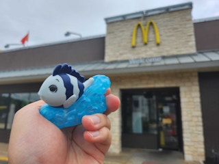 someone holding a sebastion mcdonalds toy