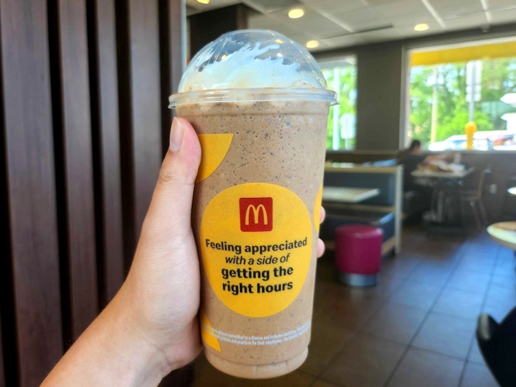 person holding a mcdonalds oreo frappe in restaurant