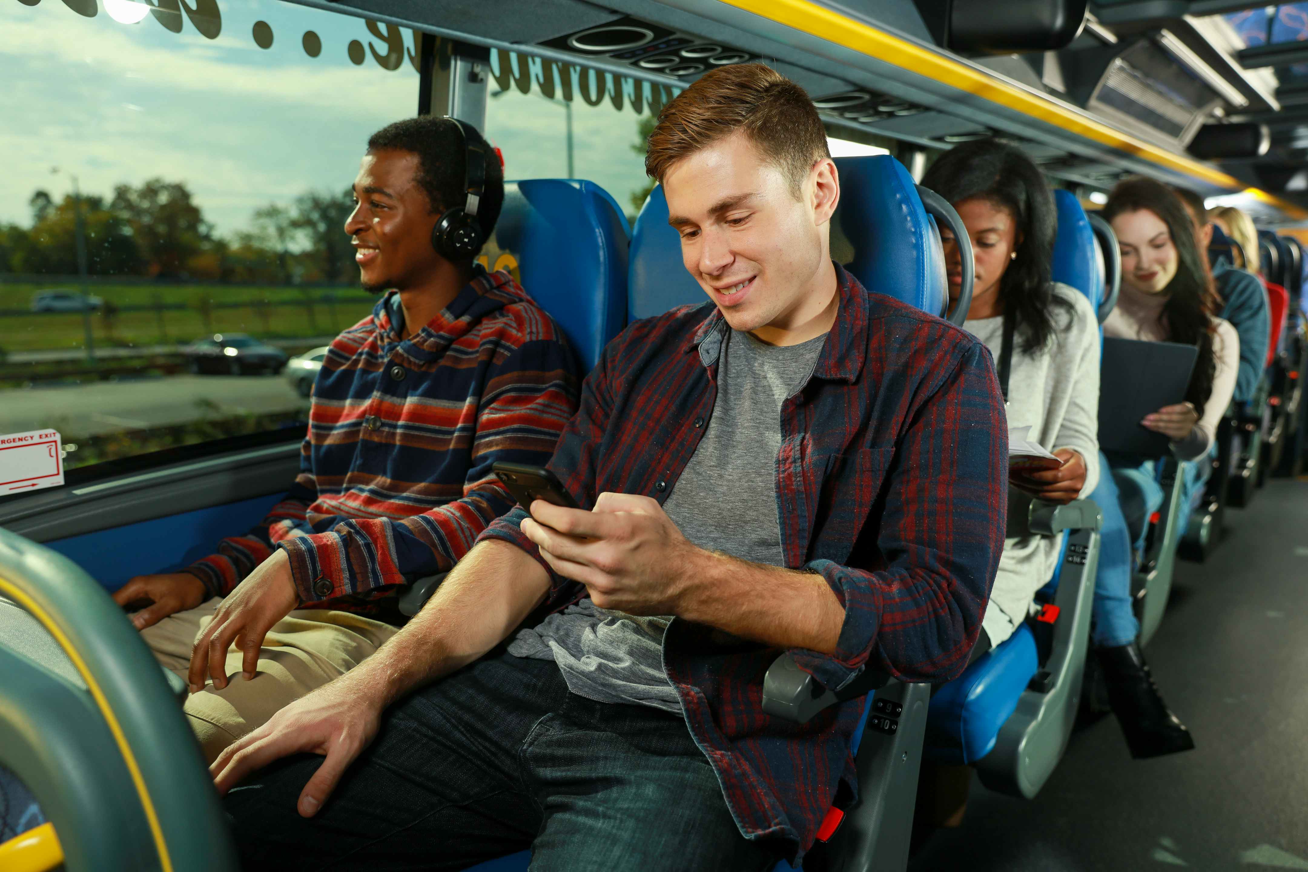 People on their phones and laptops while riding on a Megabus