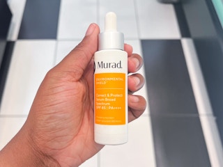 Someone holding up some Murad Serum