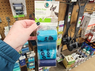 hand holding a pack of dog waste bags