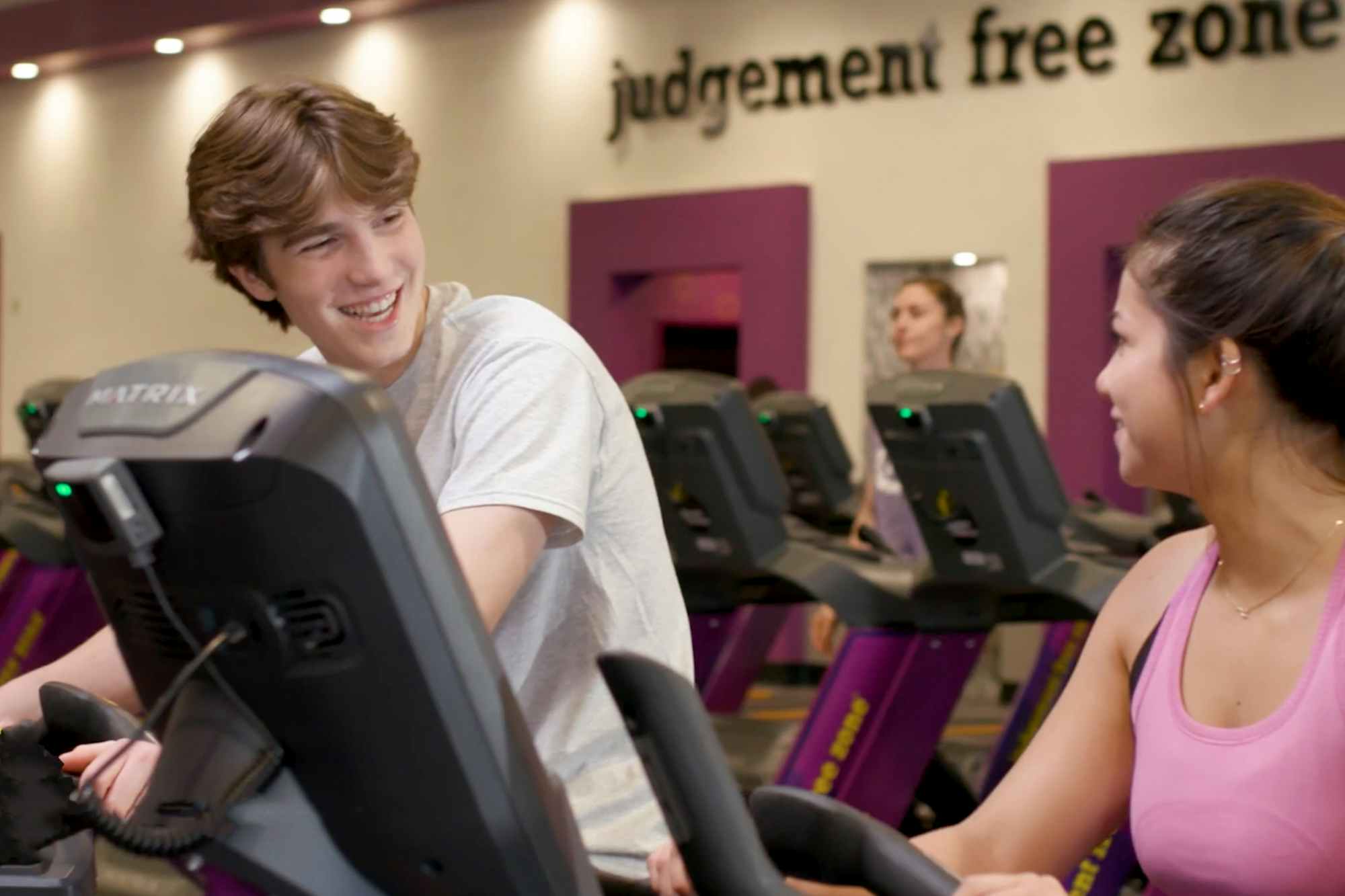 Two teens talking while on stationary bikes