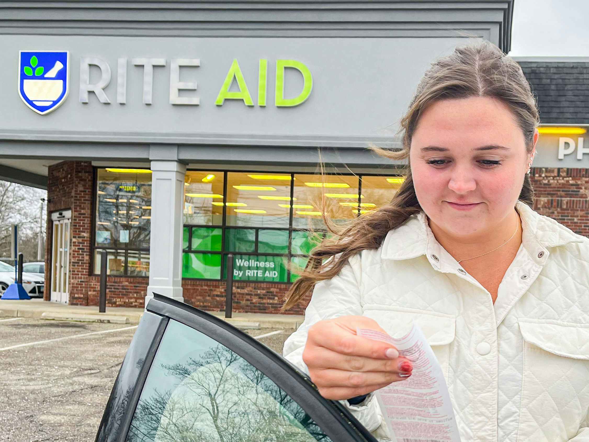 a person standing outside of a Rite Aid store