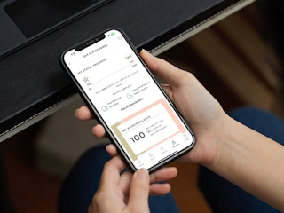 Someone holding a phone looking at their status on the Saks off 5th app