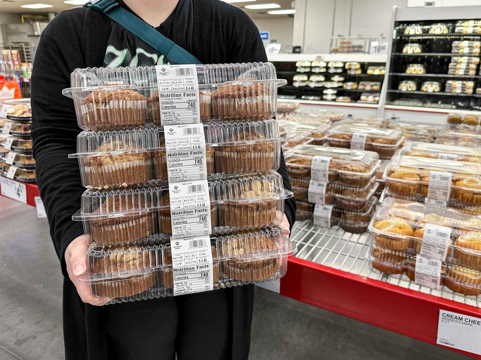 Someone holding a stack of muffins at the Sam's Club Bakery
