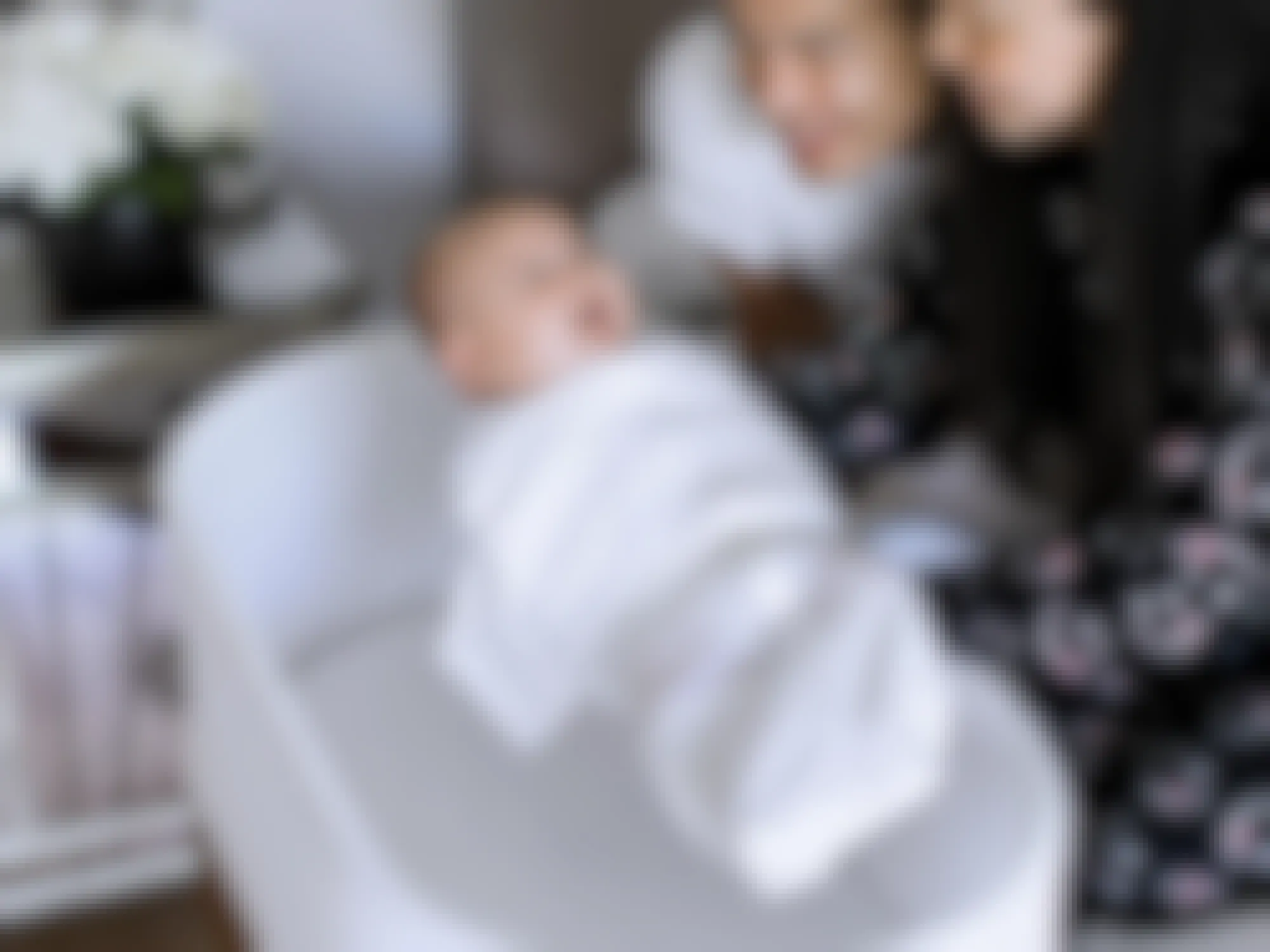 Parents placing their baby into a SNOO Bassinet