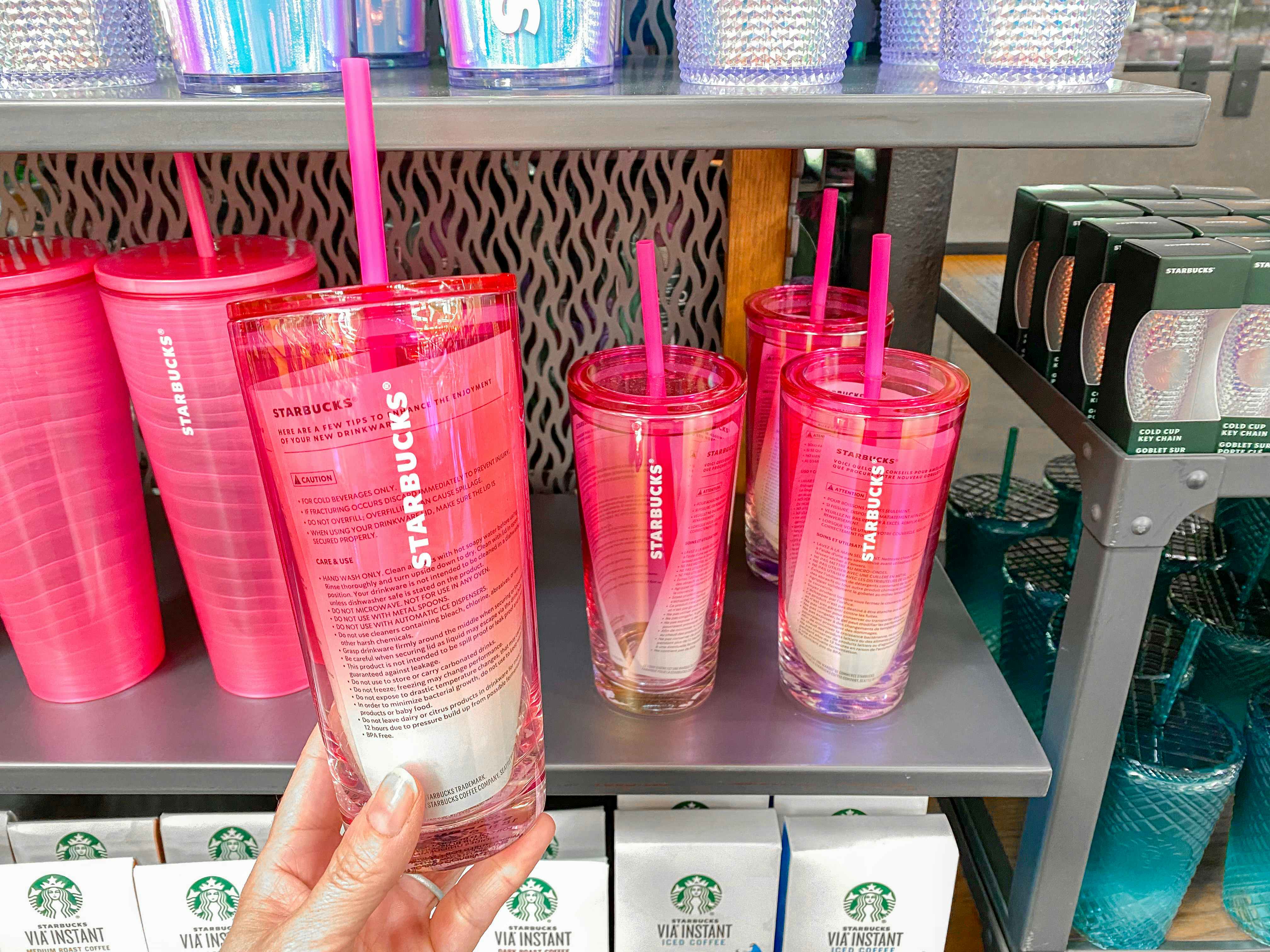 a hand holding a starbucks clear pink ombre cold cup at starbucks