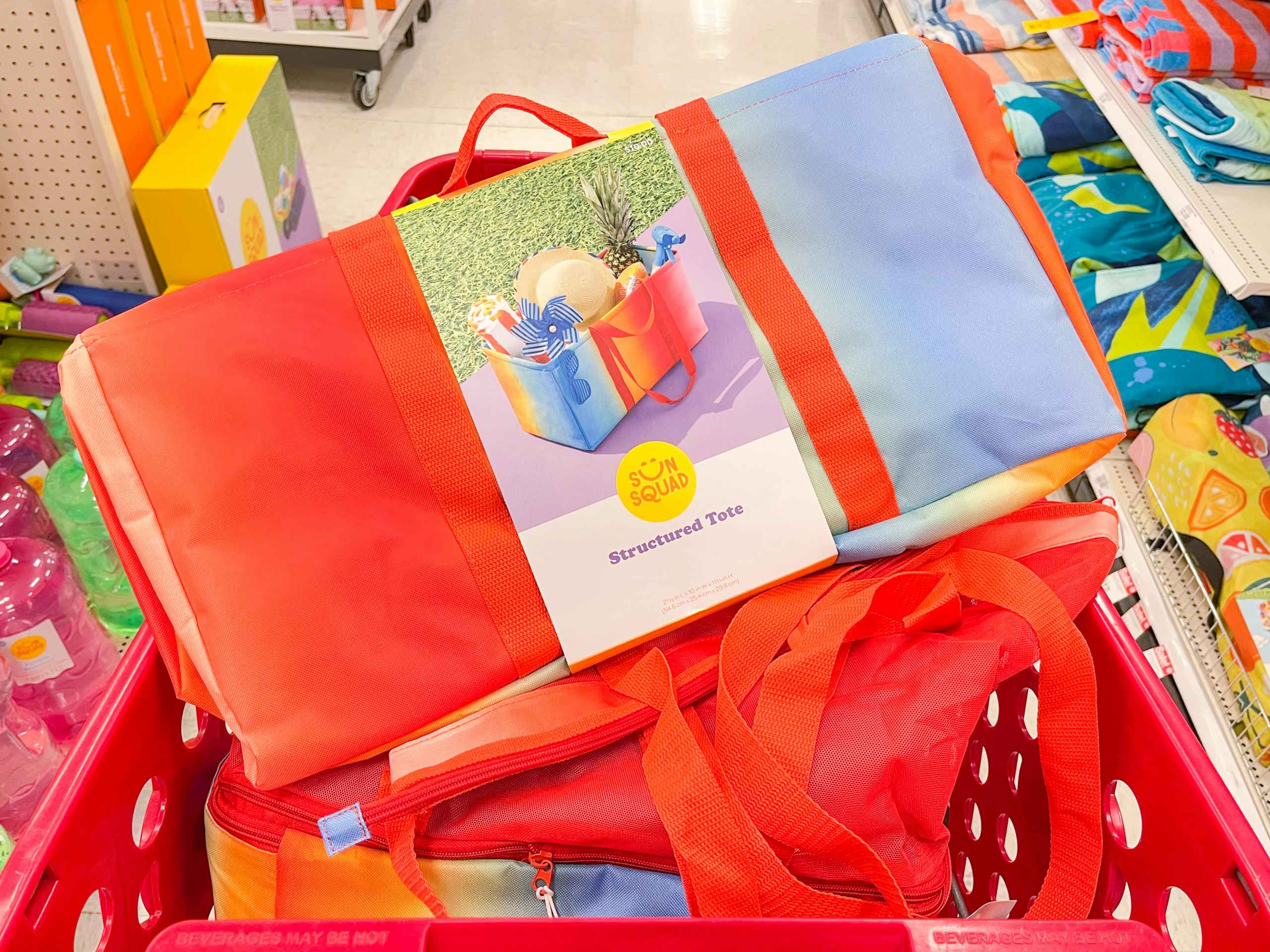 A Sun Squad Structured tote lying on top of a Sun Squad Beach Bag in a shopping cart.