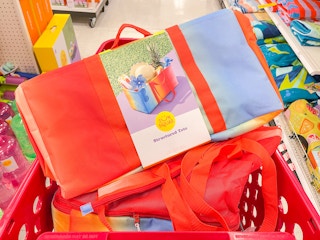 A Sun Squad Structured tote lying on top of a Sun Squad Beach Bag in a shopping cart.