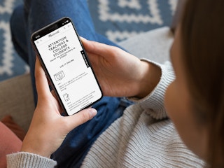 a person looking at the teacher and student discount at madewell on their iphone