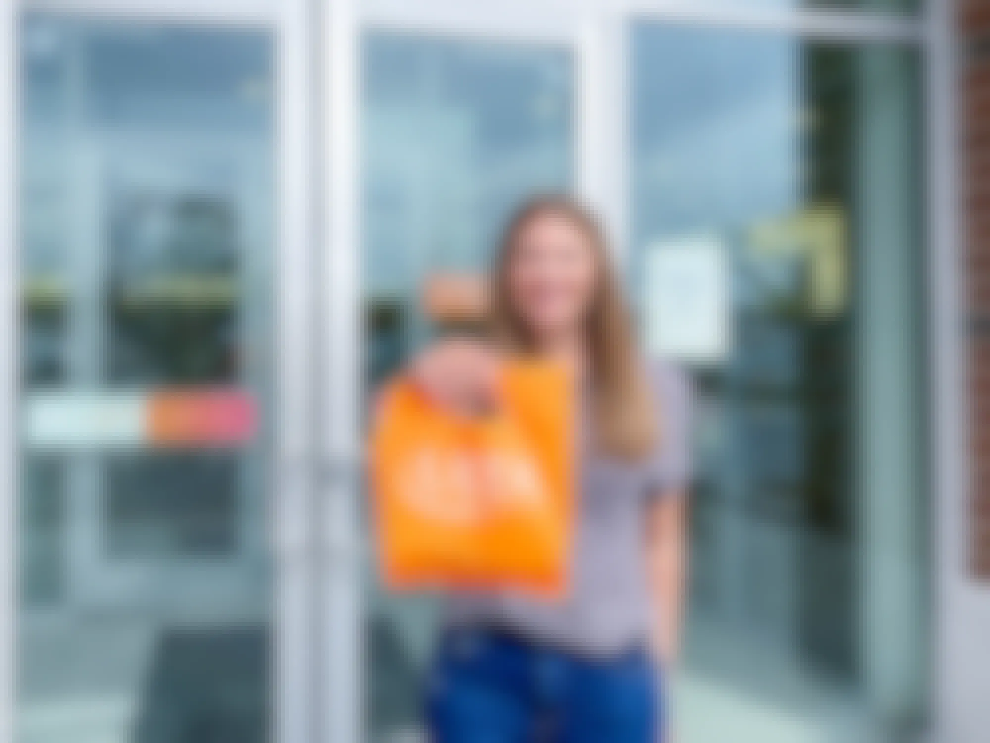 A person holding up a bag of items purchased from Ulta in front of an Ulta store
