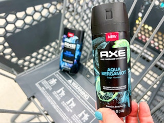 Someone putting Axe Blue Lavender deodorant stick and Aqua Bergamot body spray into a Walgreens cart