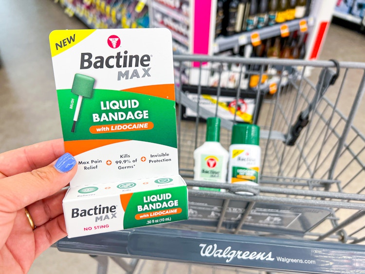 Someone putting Bactine Max products into a Walgreens cart