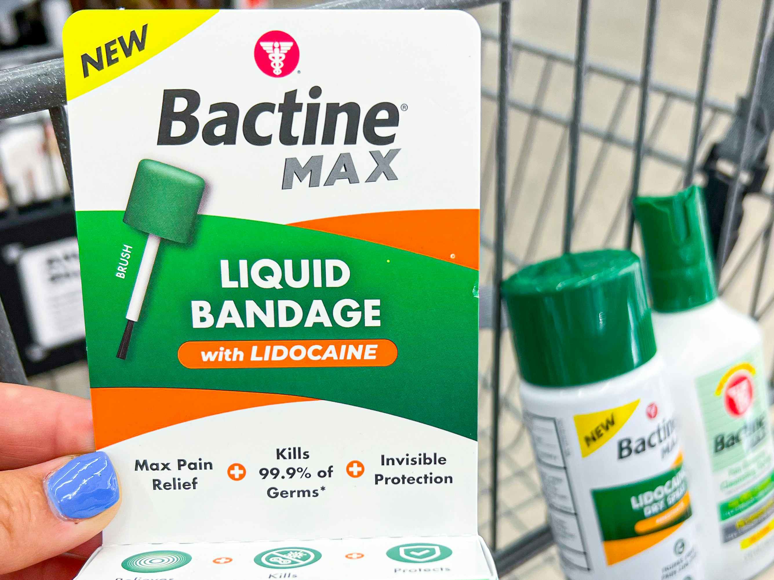 Someone holding up some Bactine Max liquid bandage with Lidocane