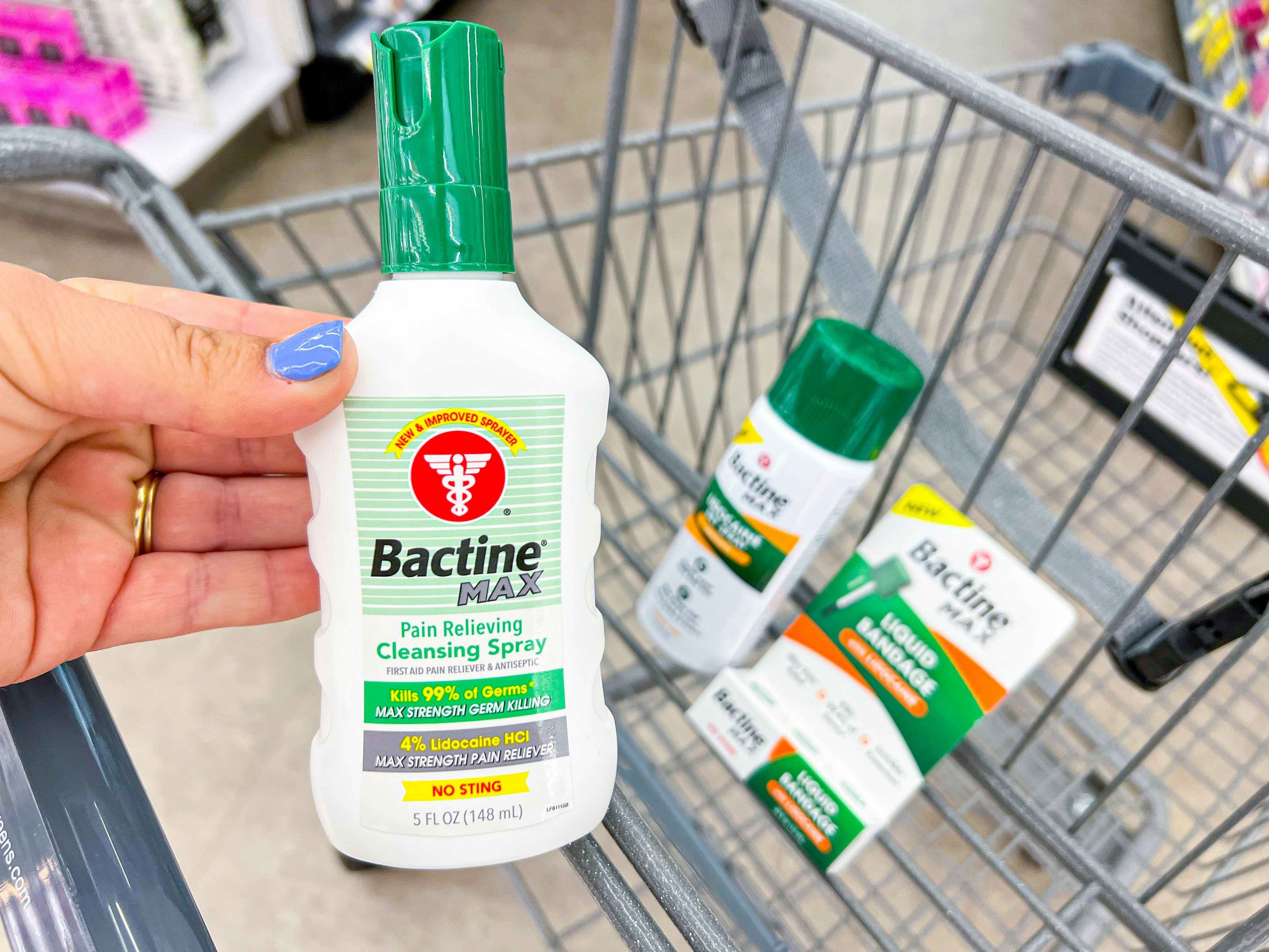 Someone putting Bactine Max products into a Walgreens cart