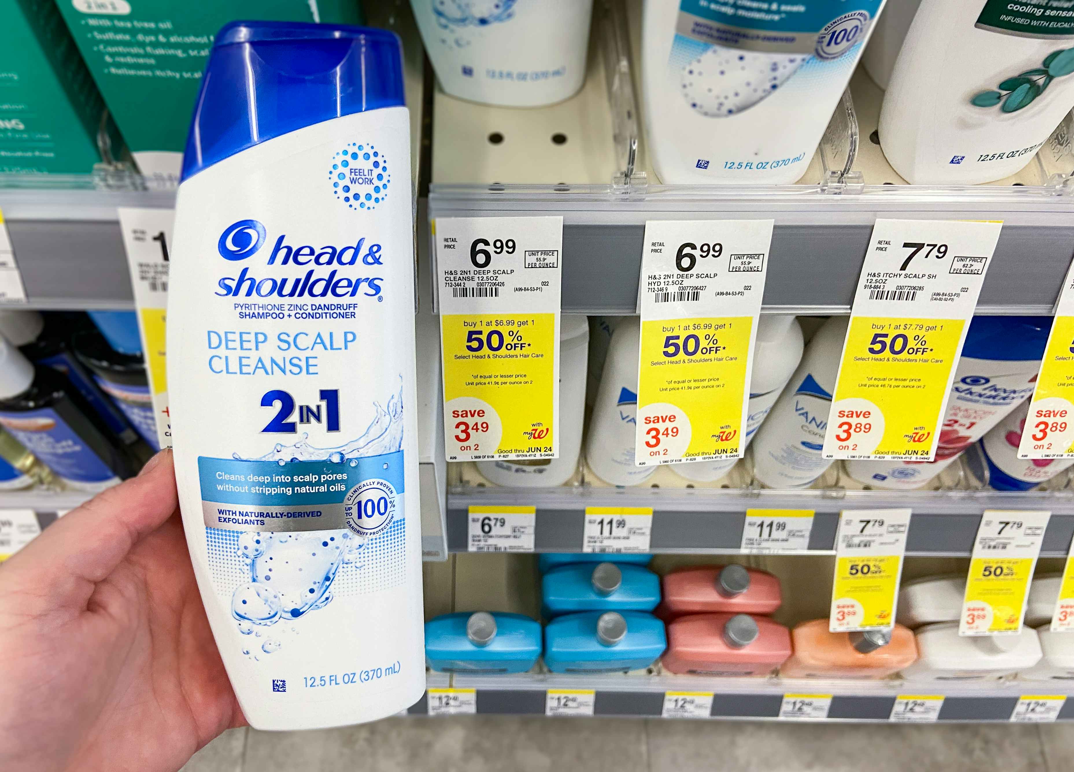 hand holding a bottle of head & shoulders hair care by a walgreens sales tag