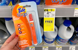 hand holding Tide to go stain eraser pen by a walgreens sale tag