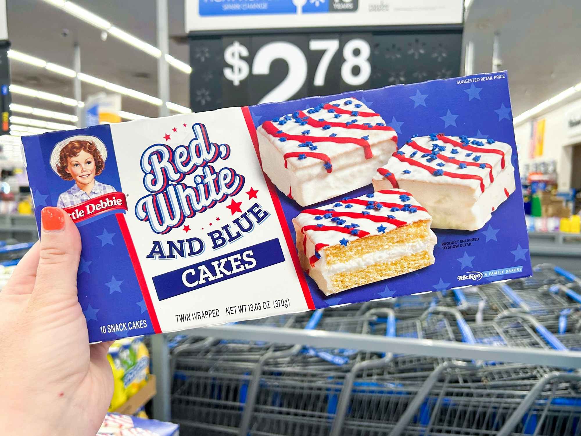 Someone holding up a box of Red White and Blue Little Debbie snack cakes in Walmart