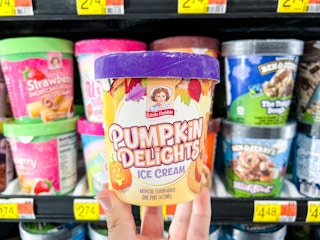 someone holding up a Little Debbie Pumpkin Delights ice cream pint