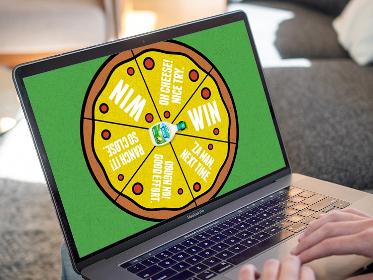 person playing a spin-to-win game for hidden valley ranch and marketplace pizza on laptop